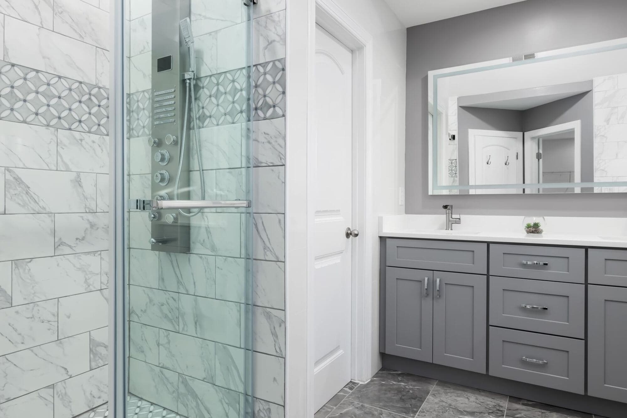 Remodeled bathroom with a tiled shower and a double vanity