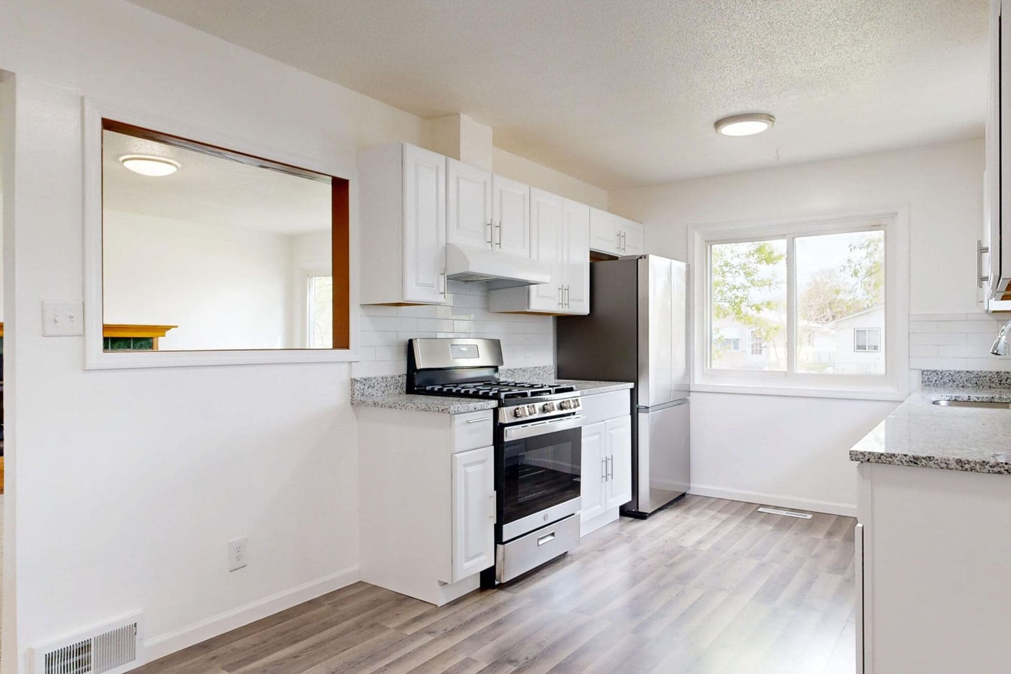 Finished kitchen with white cabinets and a gas range
